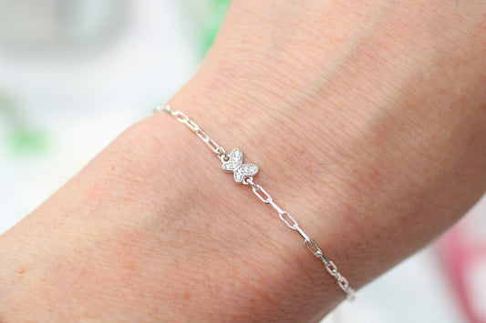 Silver butterfly bracelet on a wrist with a blurred background