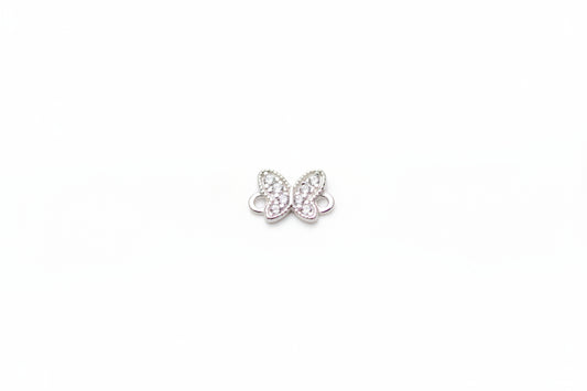 Butterfly-shaped jewelry charm on a light marble background
