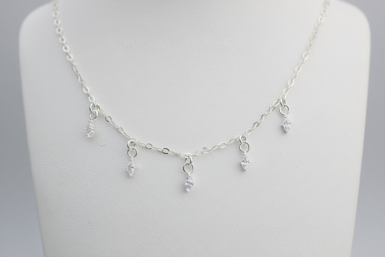 Silver necklace with small crystal marquis shaped on a white background