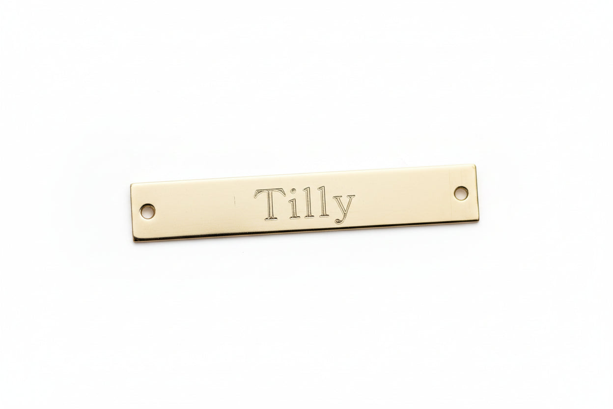 Gold nameplate with 'Tilly' engraved on a marble background