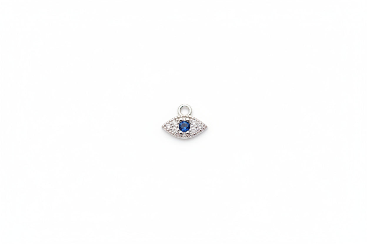 Silver pendant with a blue gemstone on a marble surface