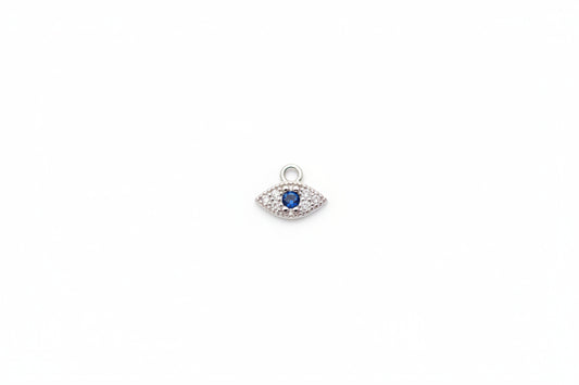 Silver pendant with a blue gemstone on a marble surface
