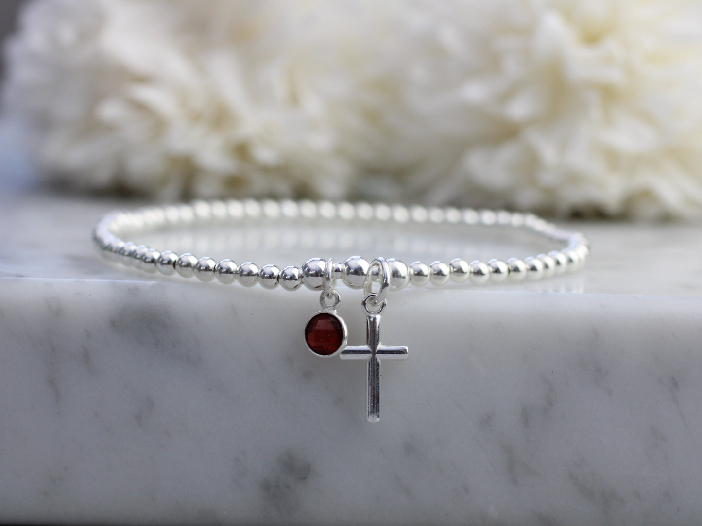 Garnet charm and cross bracelet.