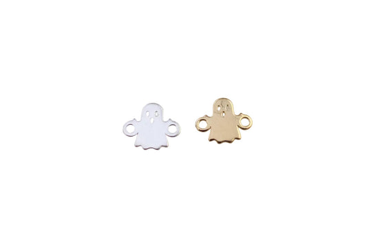 Two ghost-shaped charms, one white and one gold, on a light gray background.