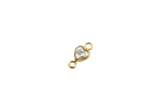 Gold heart-shaped jewelry connector with a clear gemstone on a light gray background