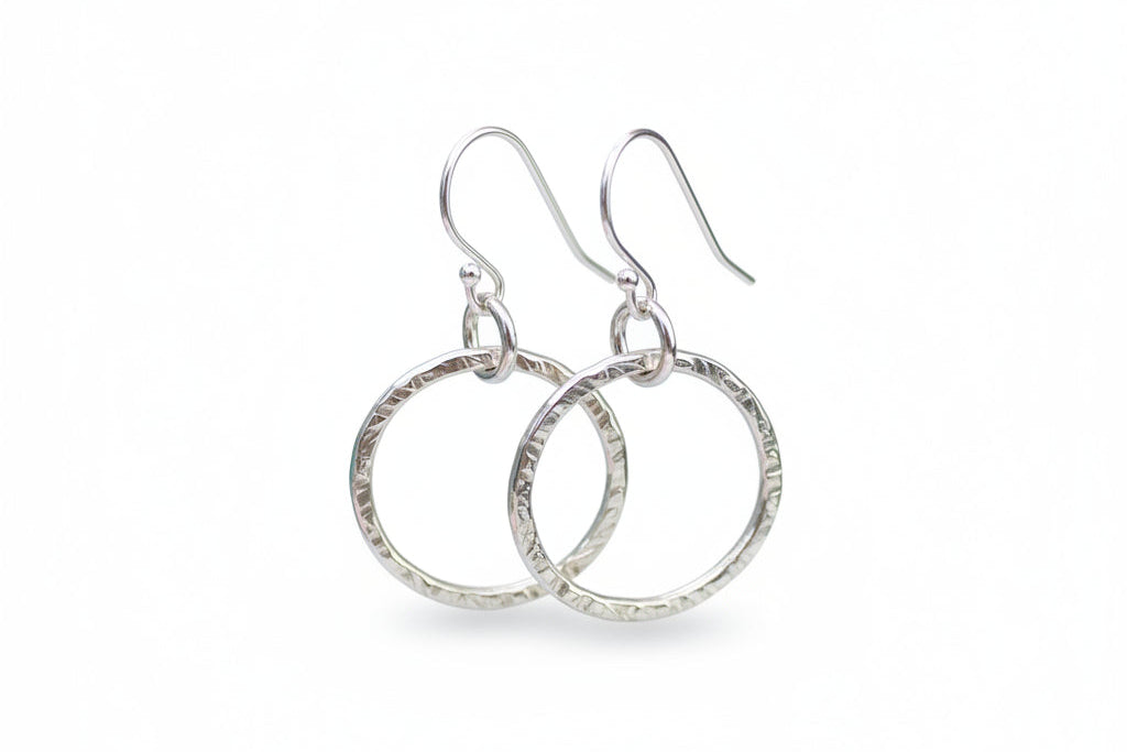 Pair of silver hoop earrings on a white background
