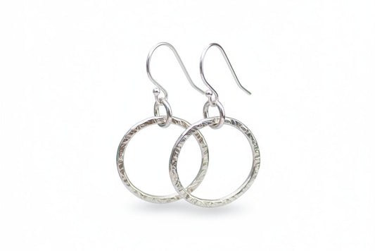Pair of silver hoop earrings on a white background