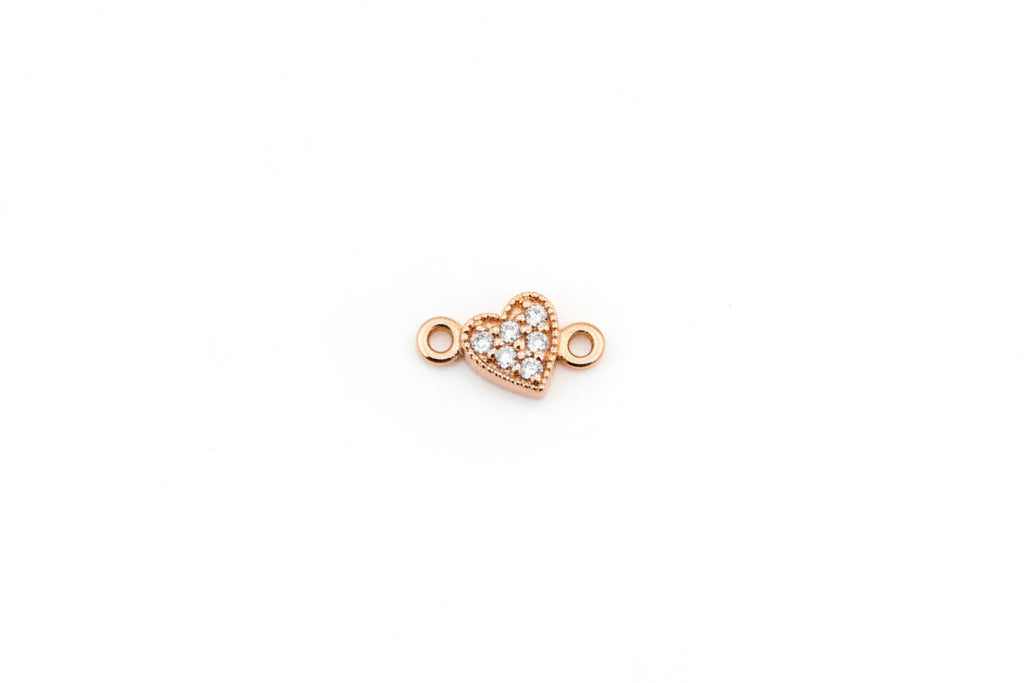Gold heart-shaped jewelry clasp on a marble background