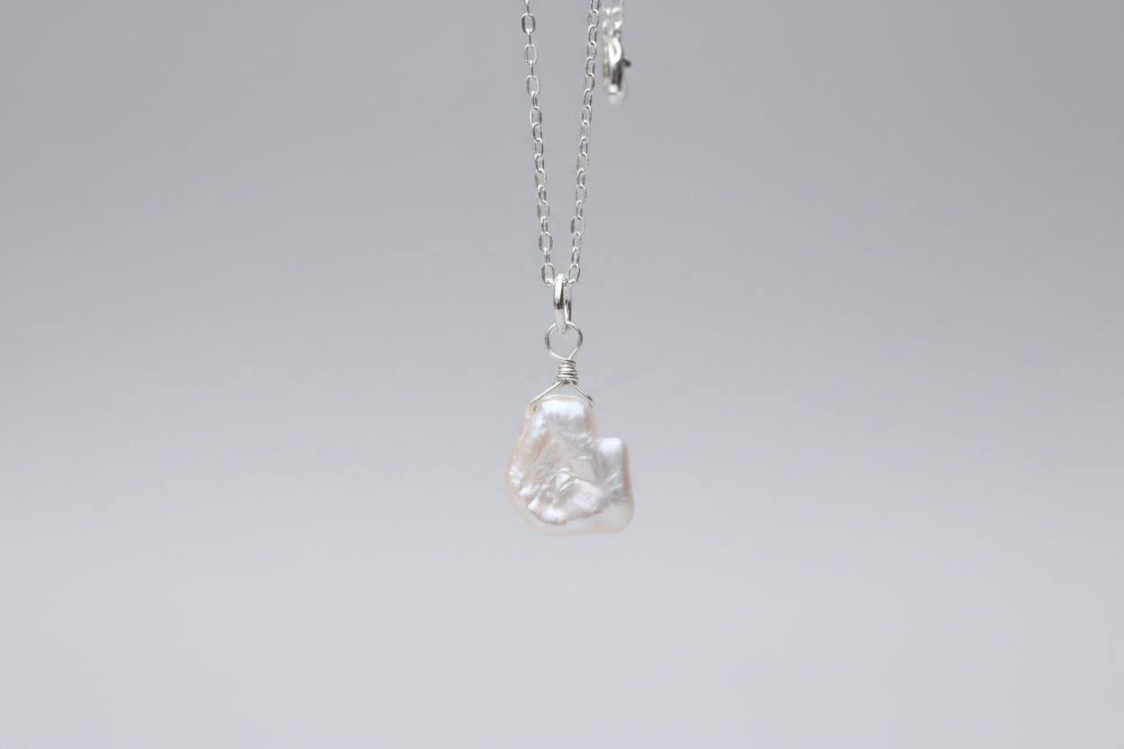 Pearl necklace on a marble surface with a blurred background