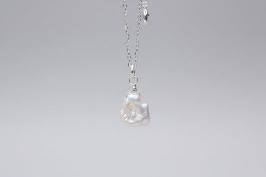 Pearl necklace on a marble surface with a blurred background