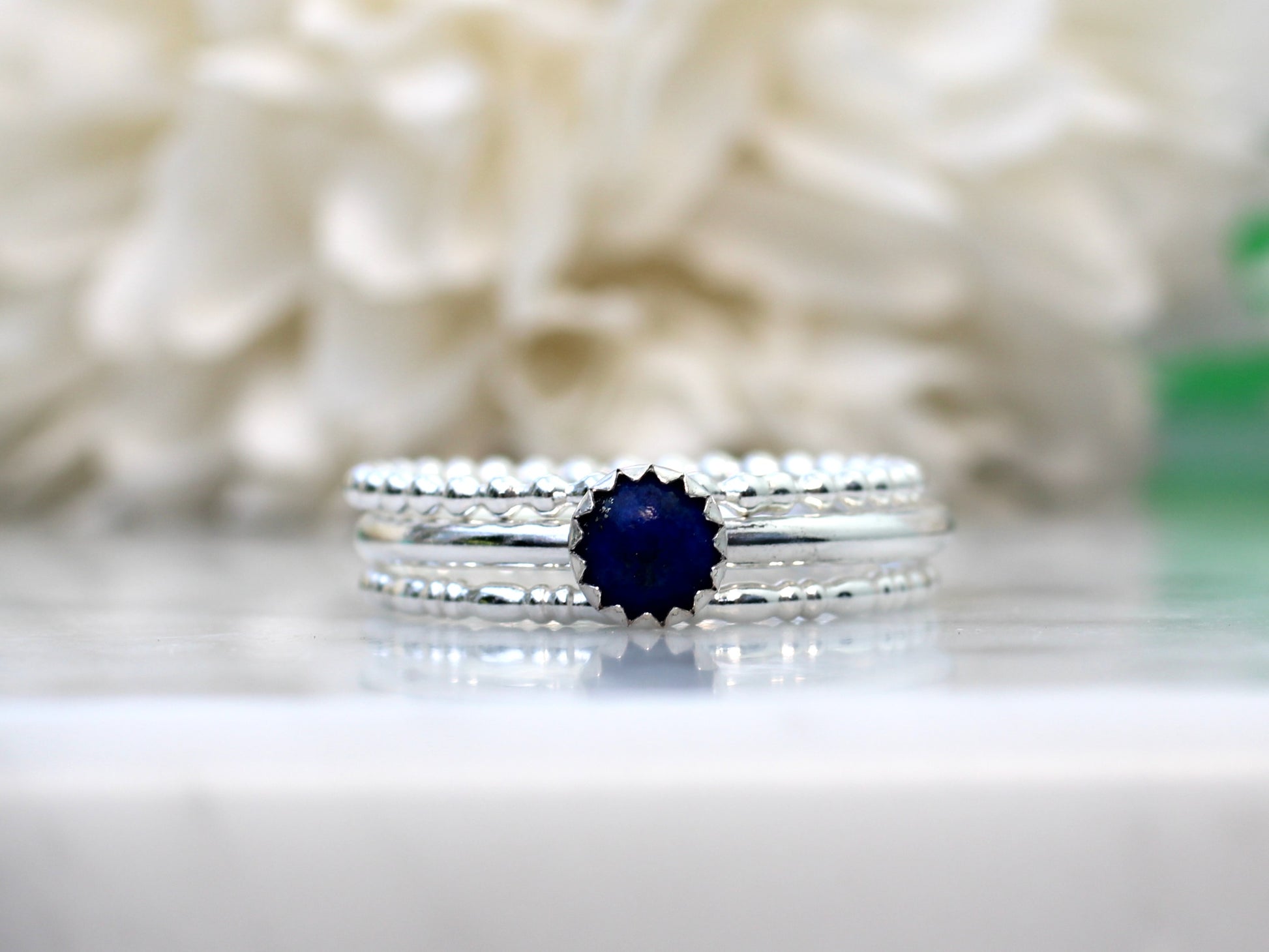 Silver ring with a blue gemstone on a gray background