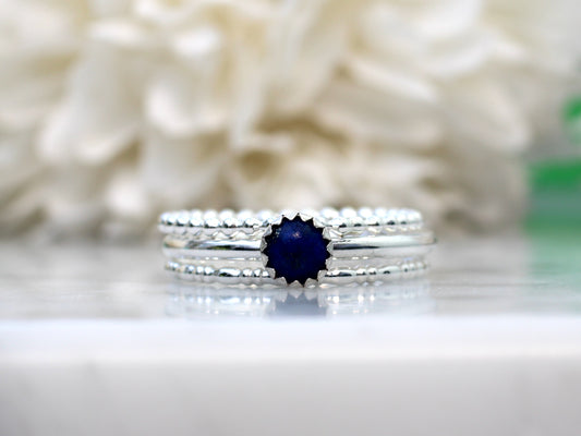 Silver ring with a blue gemstone on a gray background