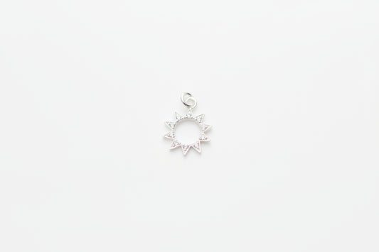 Silver sun-shaped pendant on a marble background