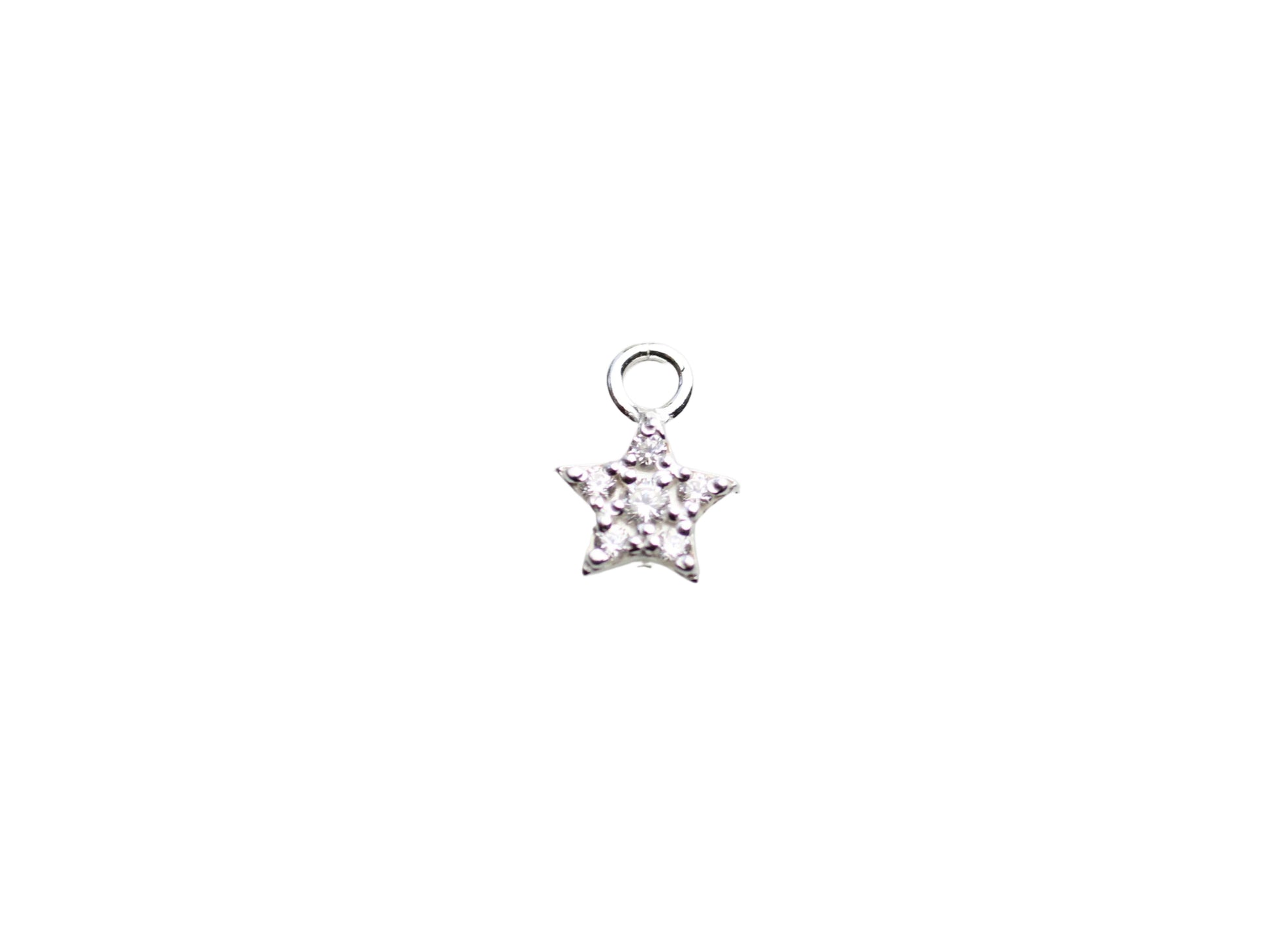 Star-shaped silver pendant with clear stones on a light gray marble background