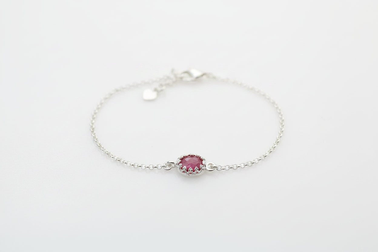 Silver bracelet with a pink gemstone on a white background