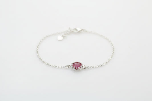 Silver bracelet with a pink gemstone on a white background