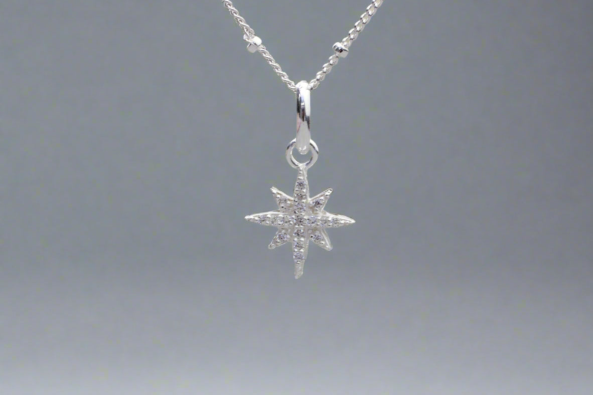 A silver North Star pendant necklace with a delicate satellite chain.