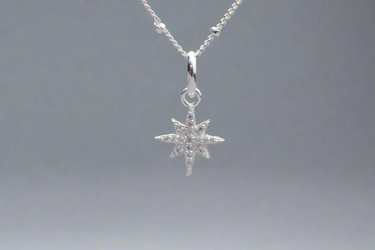 A silver North Star pendant necklace with a delicate satellite chain.
