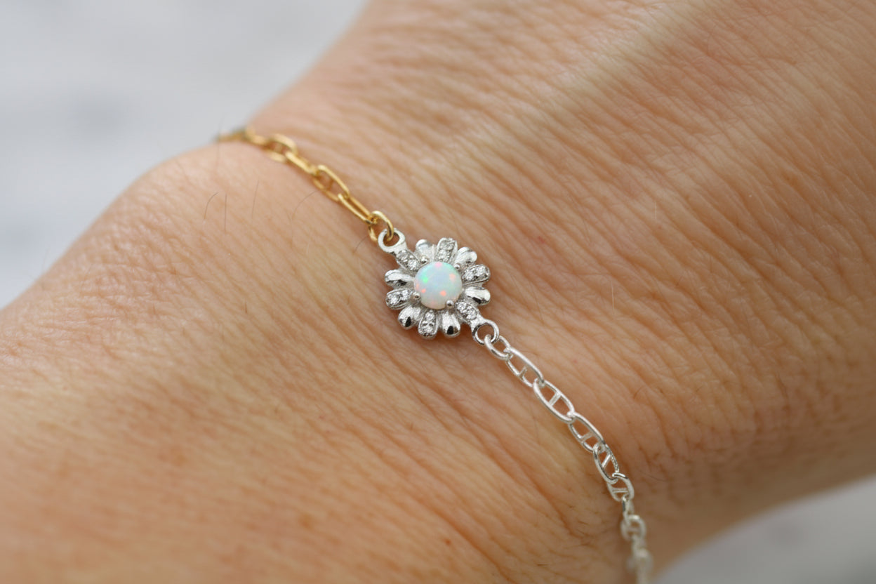 Bracelet with a floral design on a wrist against a neutral background
