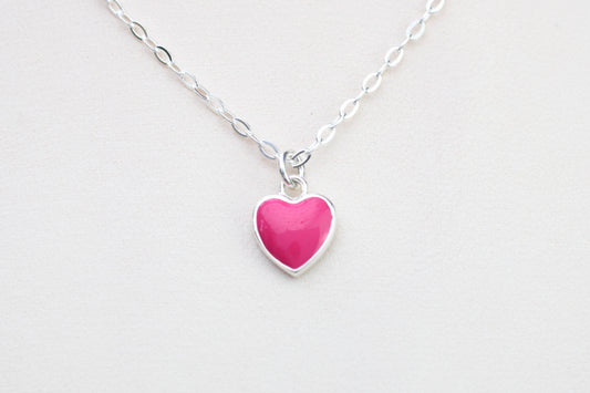 A sterling silver necklace with a pink enamel heart charm.
