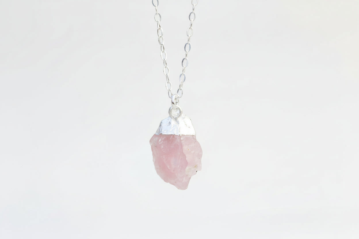 Necklace with a pink crystal pendant on a white background
