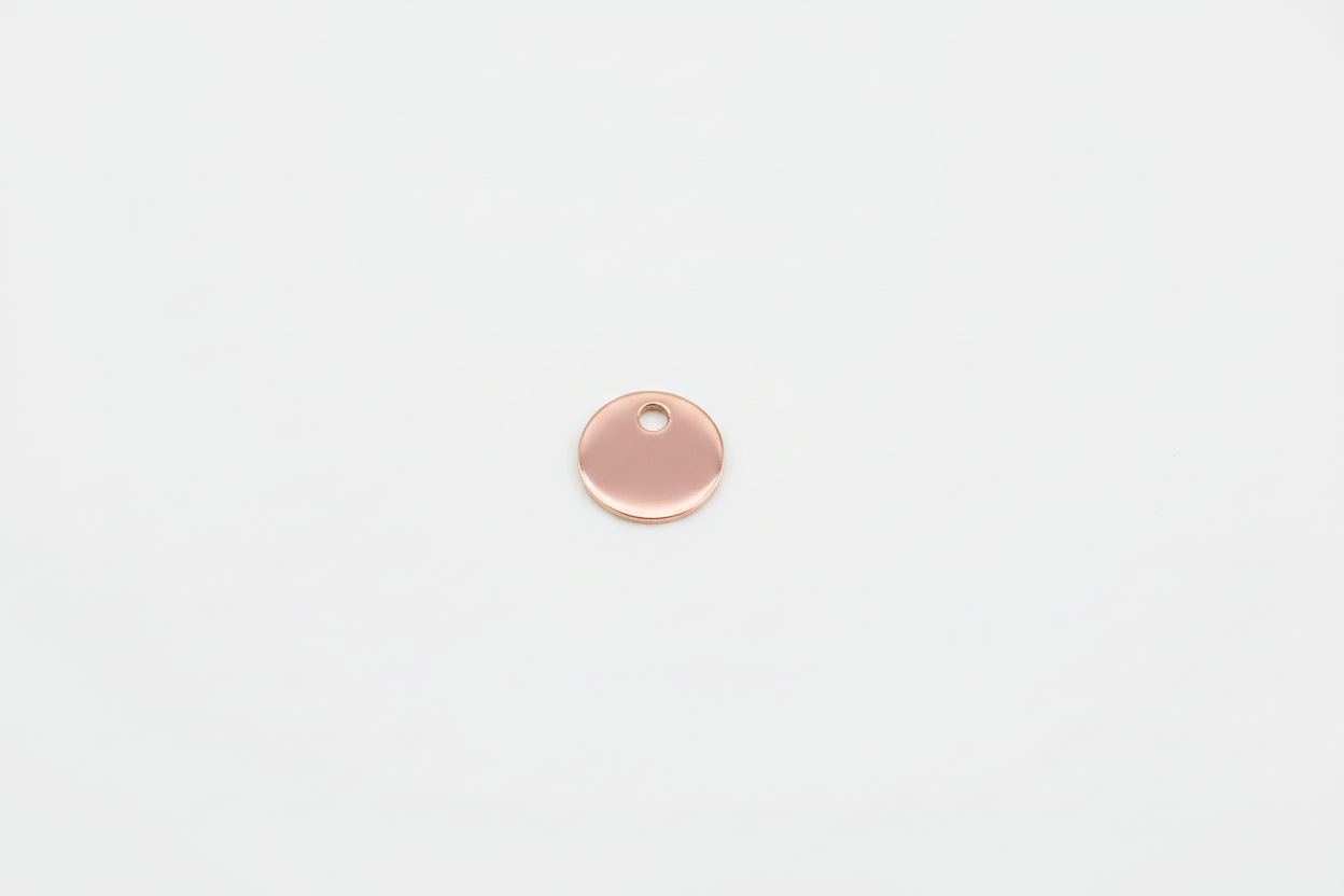 Rose gold round pendant on a marble surface