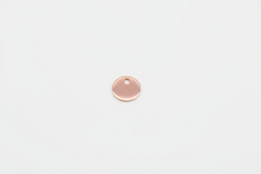 Rose gold round pendant on a marble surface