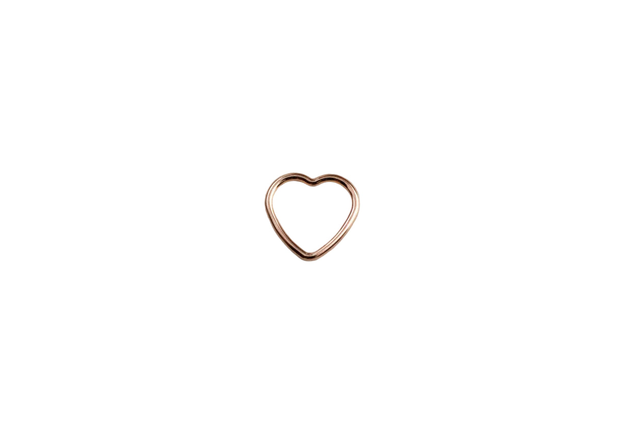 rose gold heart charm on a white surface