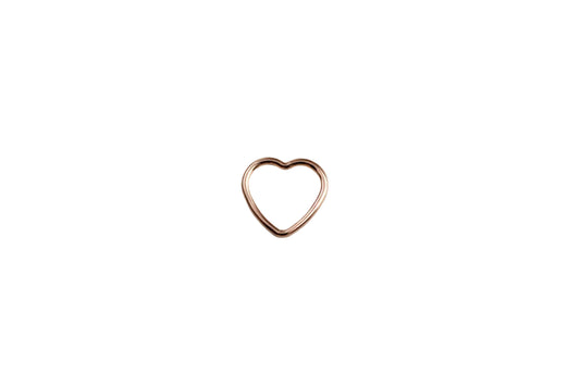 rose gold heart charm on a white surface
