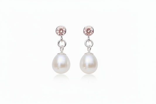 pink gemstone and pearl drop earrings with a white background