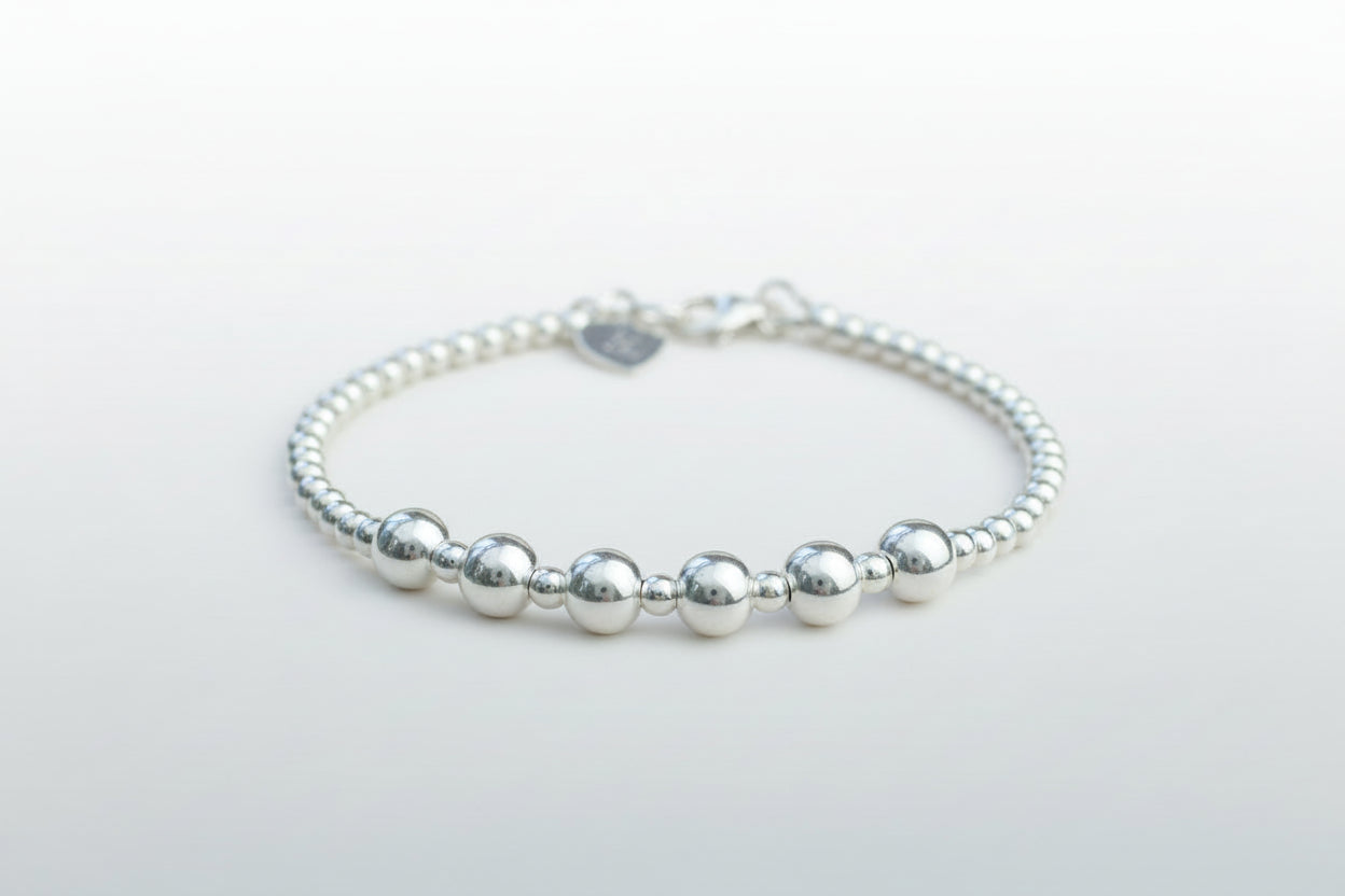 Silver beaded bracelet on a light gray background