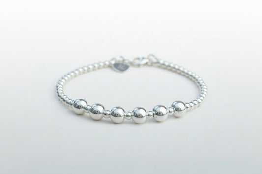 Silver beaded bracelet on a light gray background