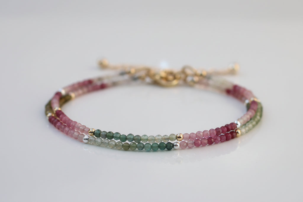 Multicolored beaded bracelet on a white surface with a blurred background