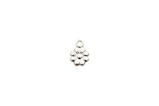 Silver flower-shaped charm on a marble background