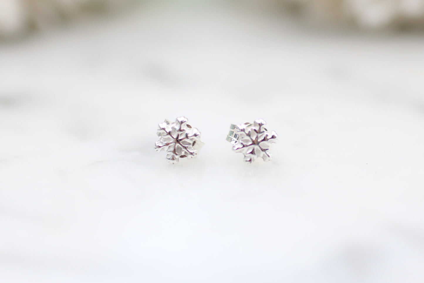 snowflake earrings on a white surface