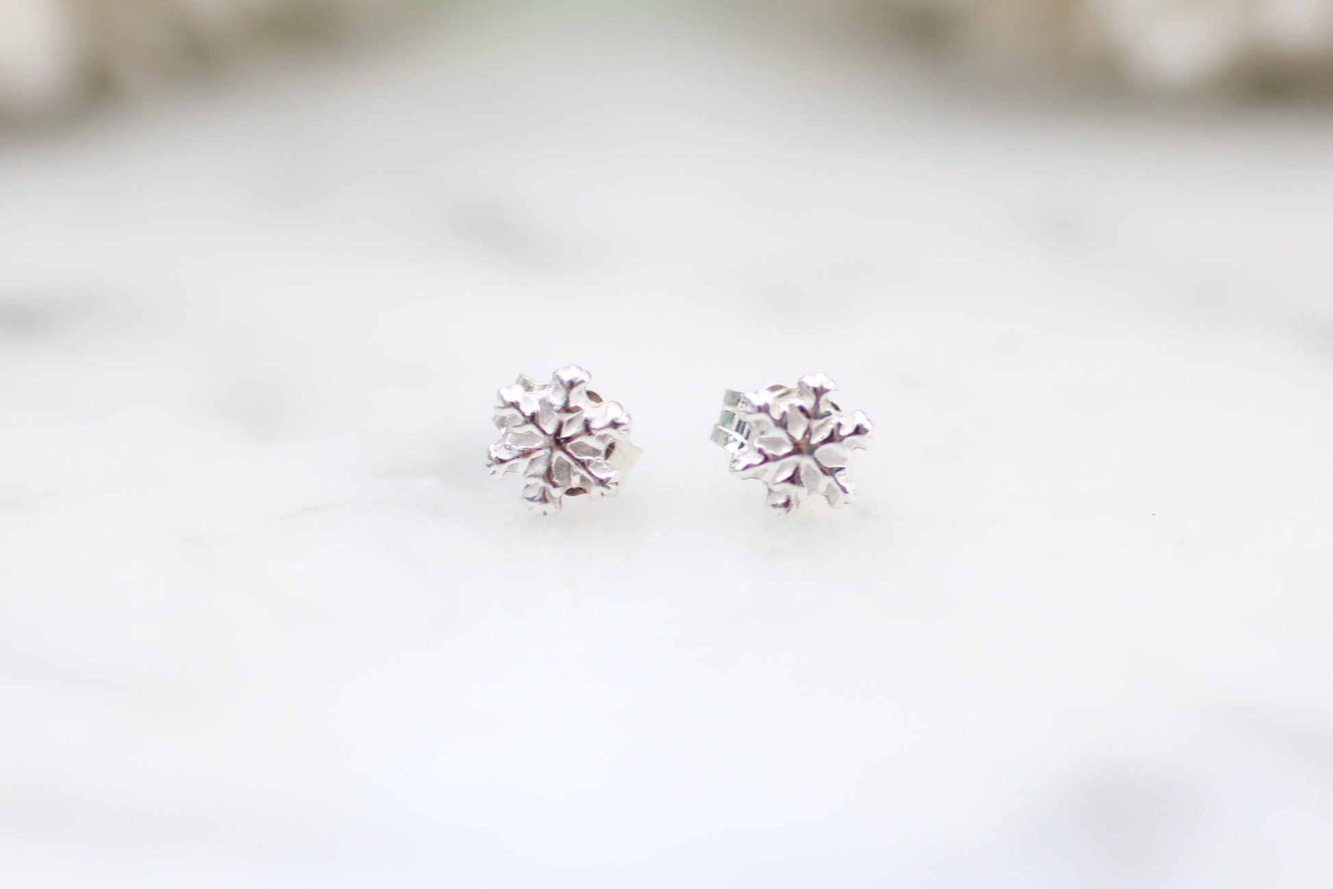 snowflake earrings on a white surface