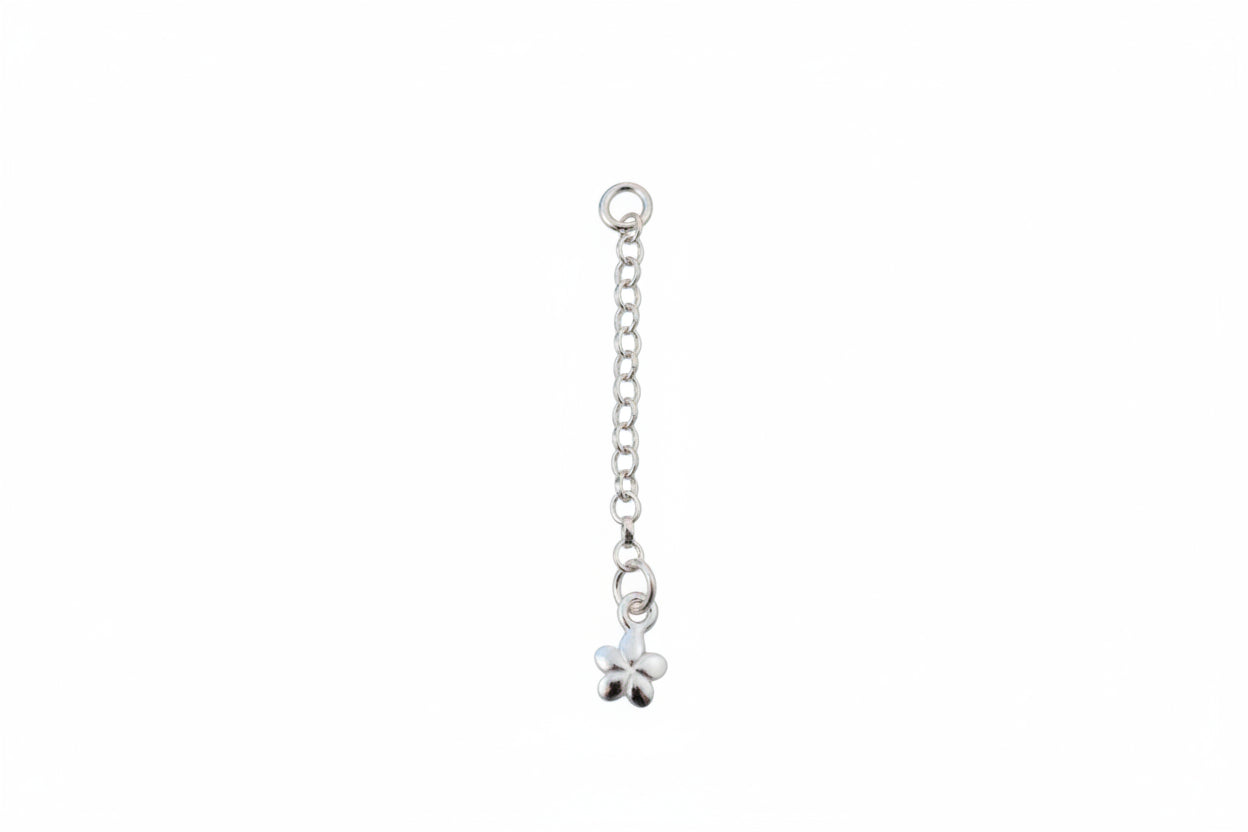 Silver chain with a flower charm on a marble background