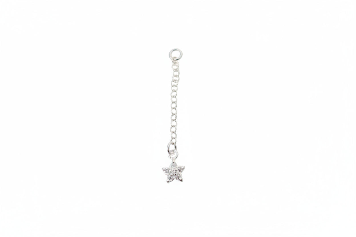 Silver star-shaped charm on a chain against a marble background