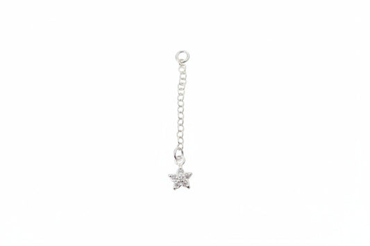 Silver star-shaped charm on a chain against a marble background