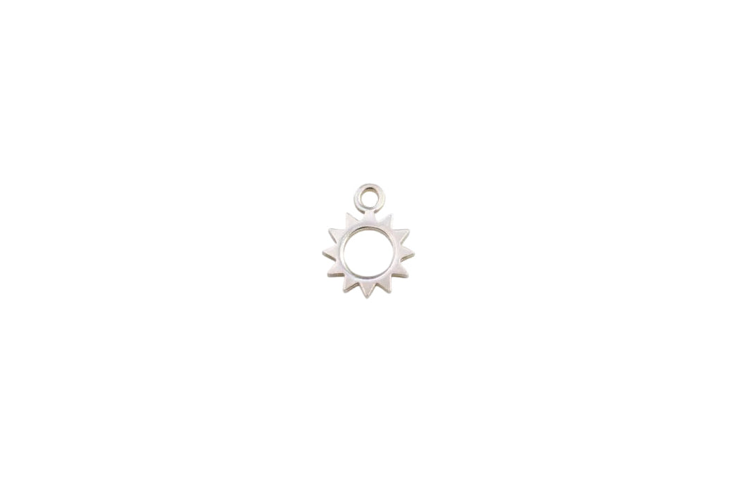 Silver sun-shaped pendant on a marble background