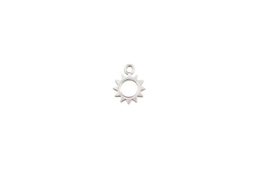 Silver sun-shaped pendant on a marble background