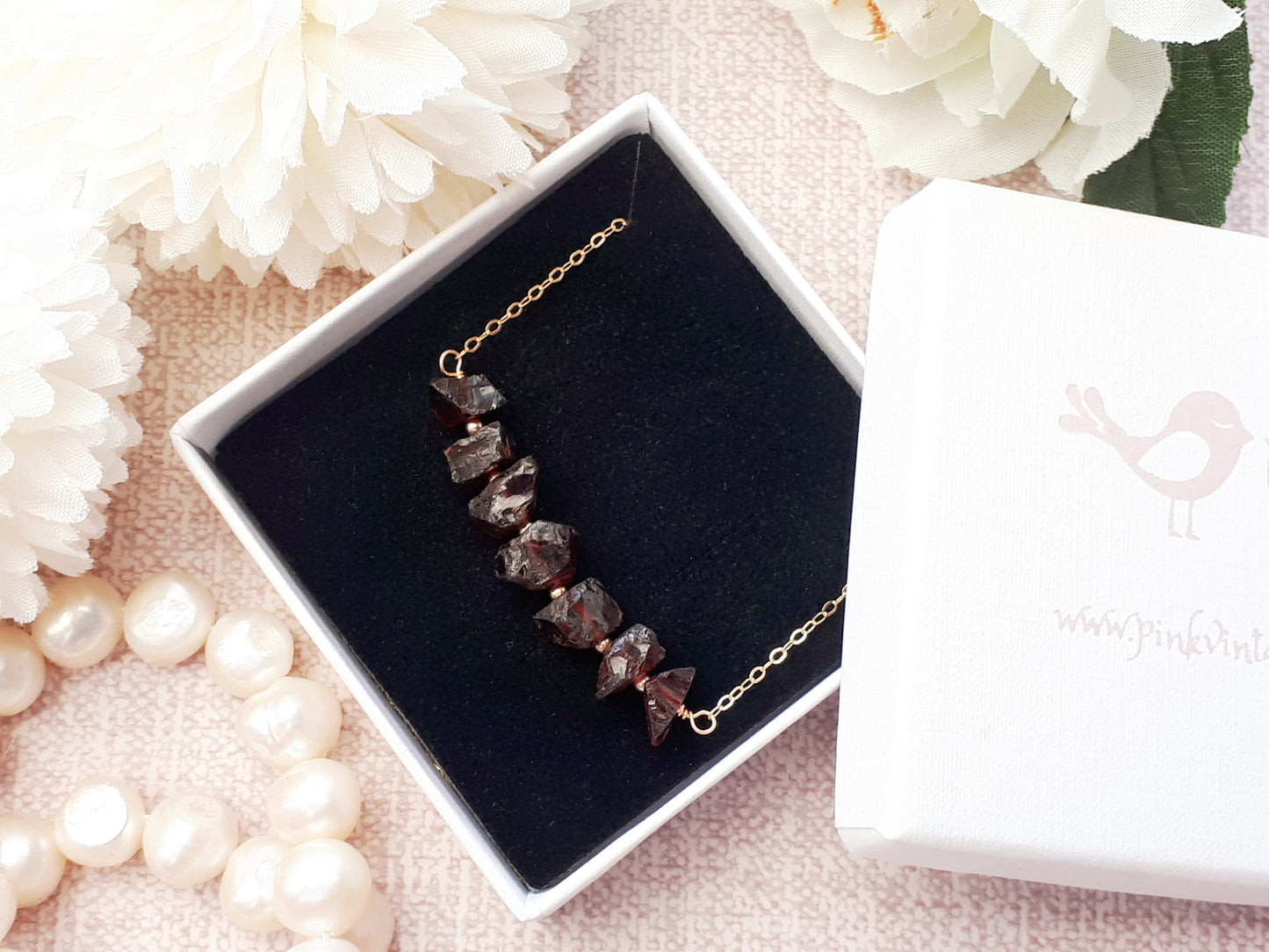 Raw garnet gemstone necklace in gold.