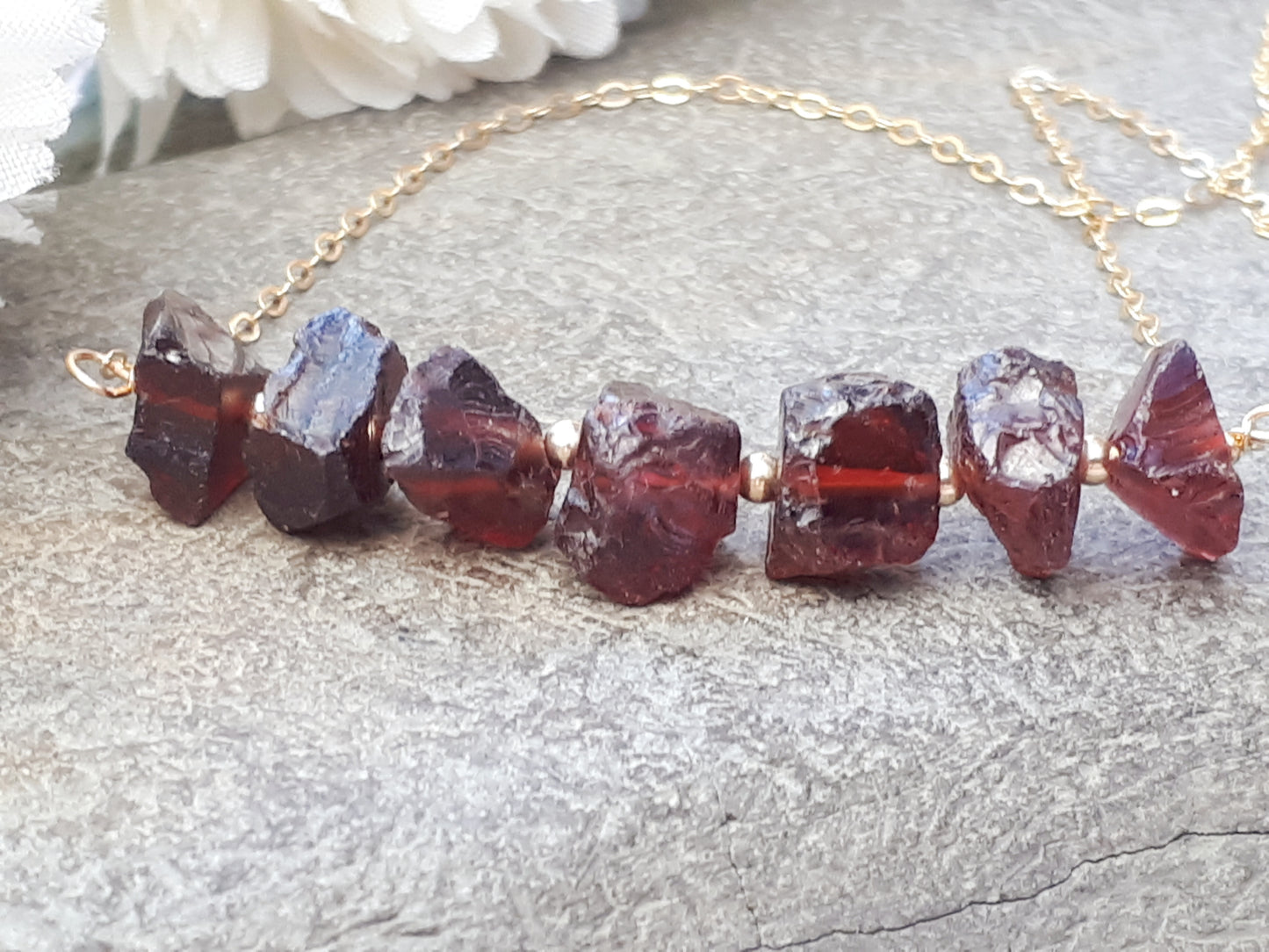 Raw garnet gemstone necklace in gold.