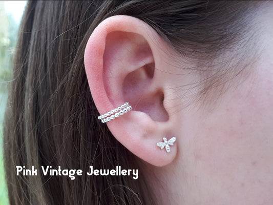 A close-up of a sterling silver beaded wire ear cuff on a person's ear, with the text 'Vintage Jewellery' visible.