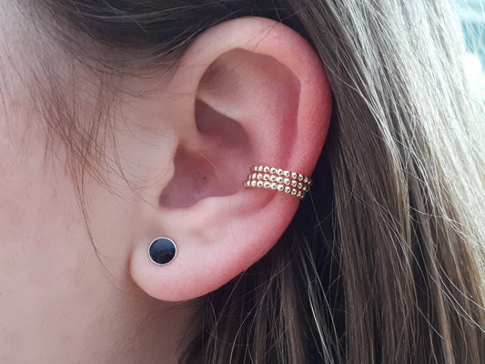 person wearing gold ear cuffs