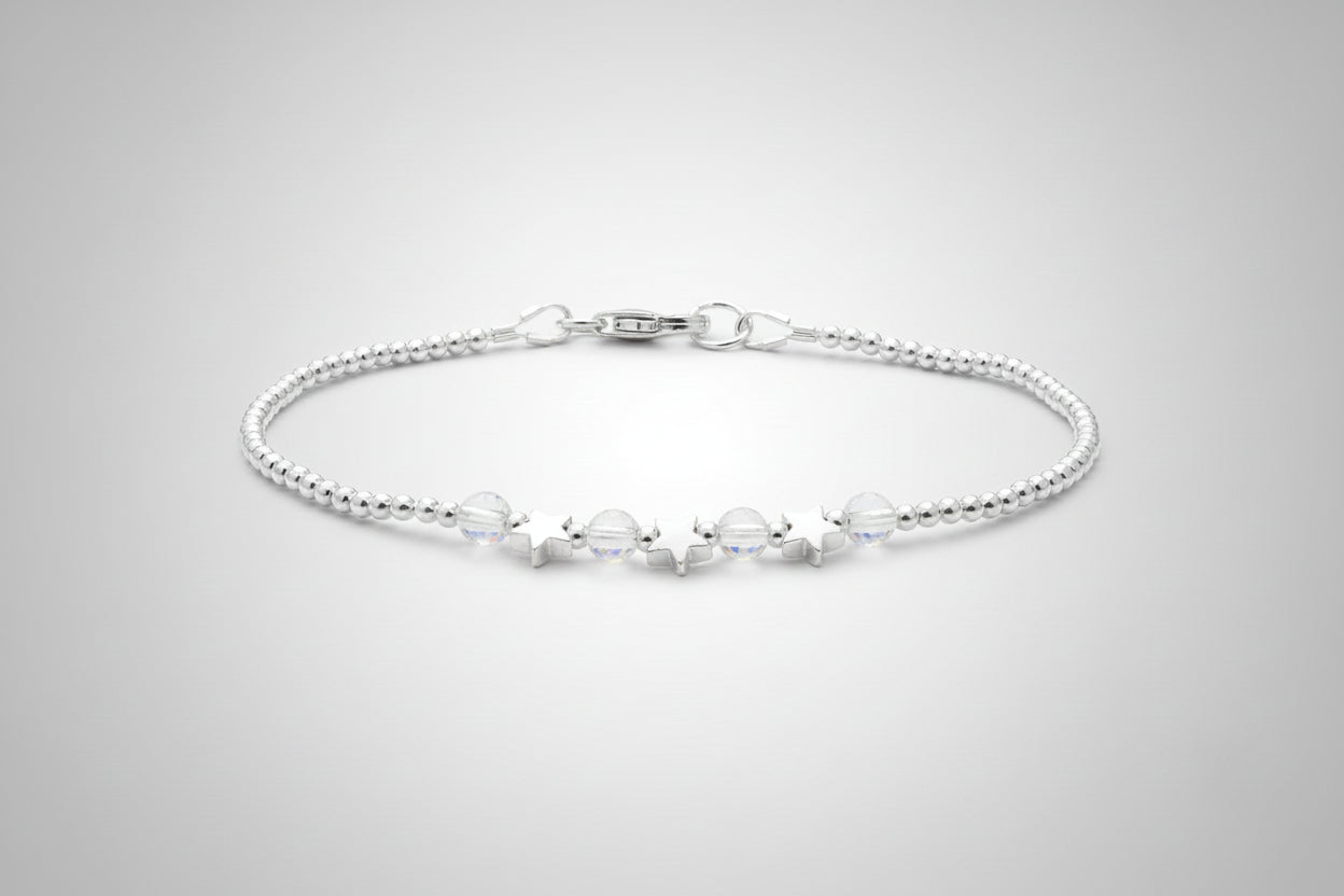 Silver bracelet with small beads on a light gray background