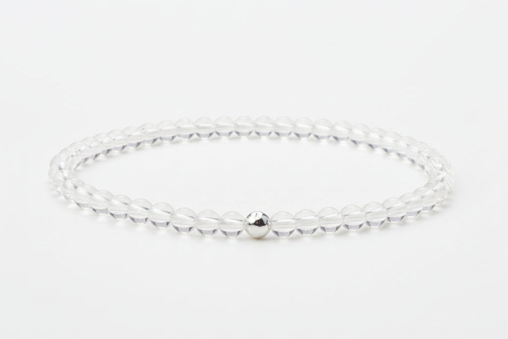 Bracelet with a small bead on a light gray background