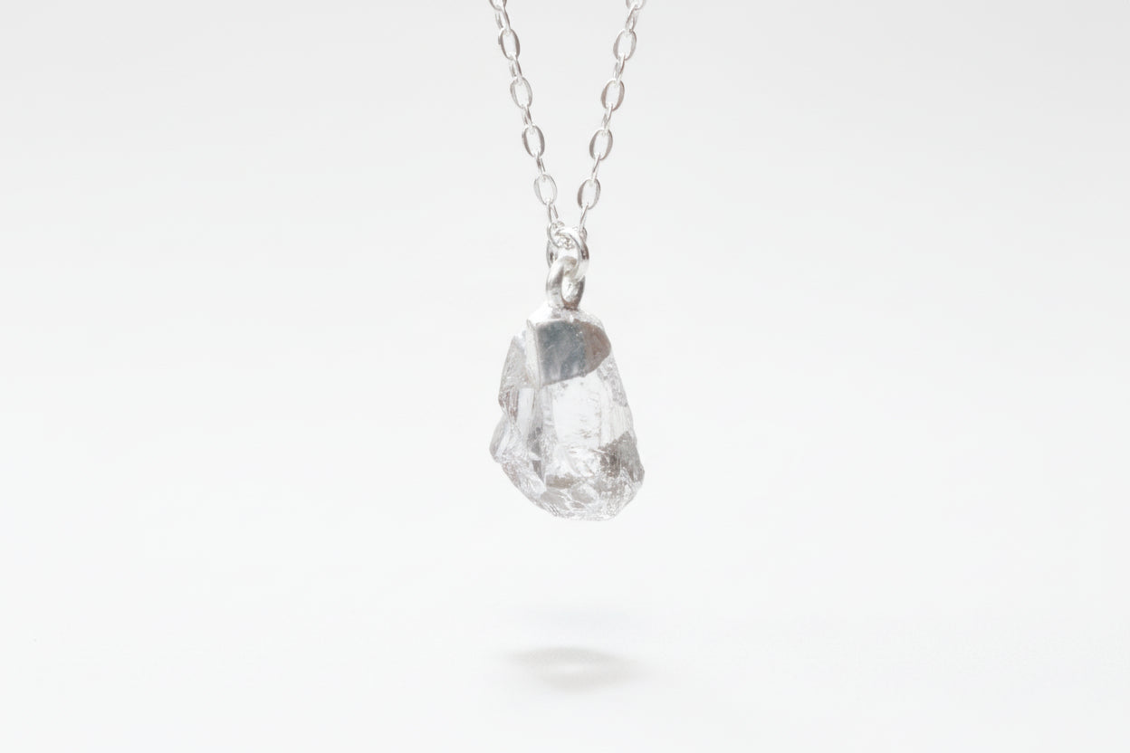 Necklace with a raw diamond pendant on a white background
